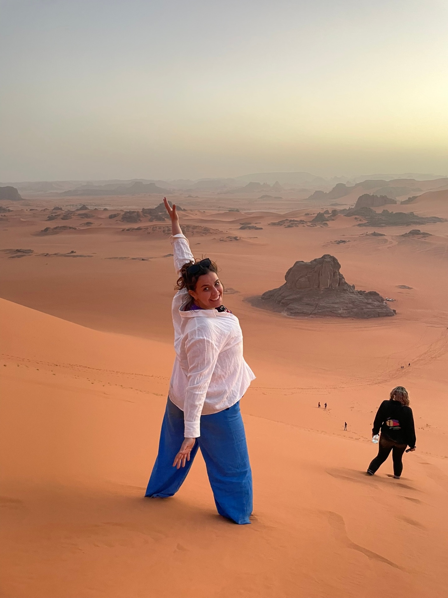 Voyageuse au sommet d’une dune de la Tadrart au coucher du soleil