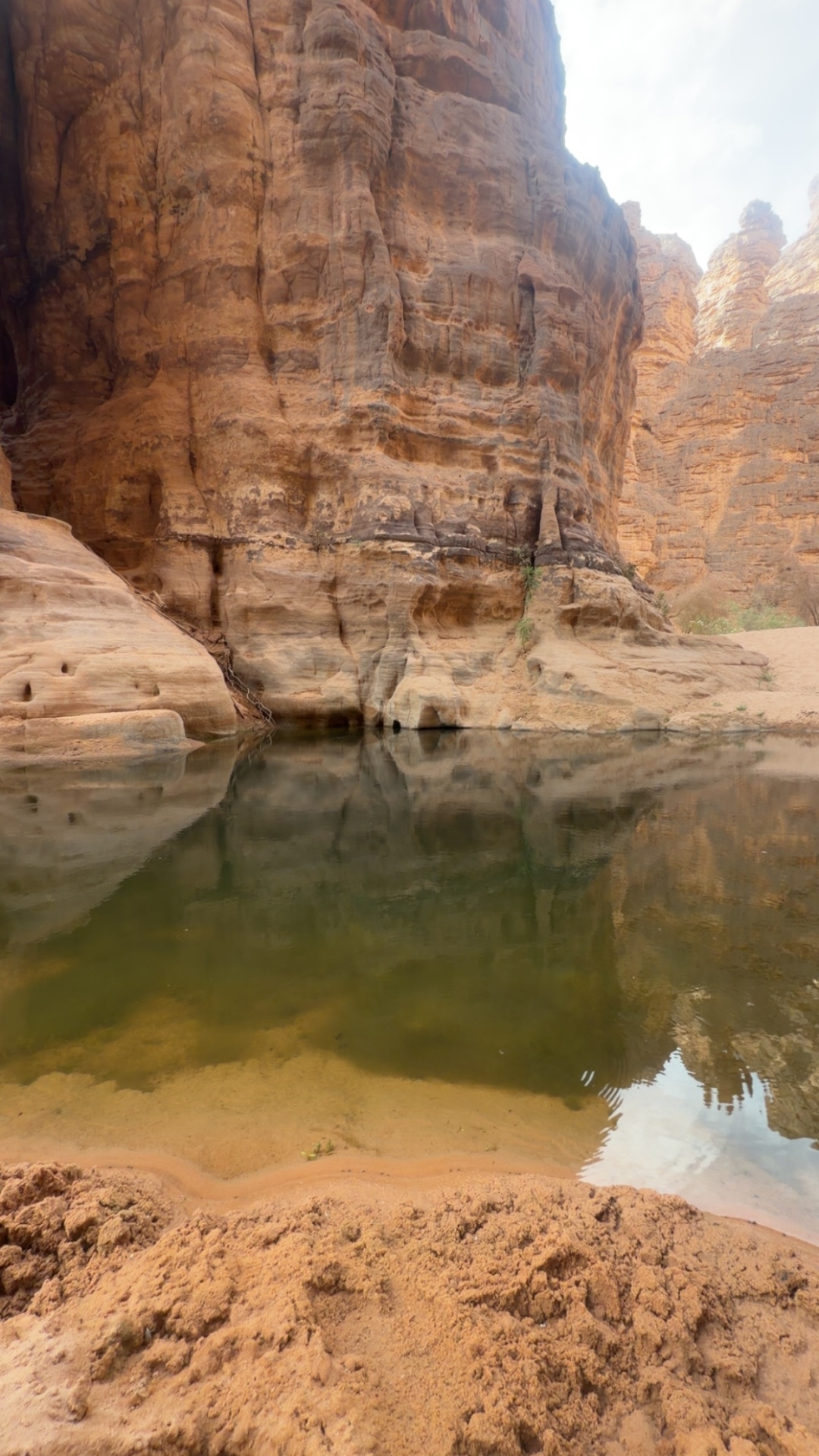 Guelta profonde au pied d’une falaise de grès orange