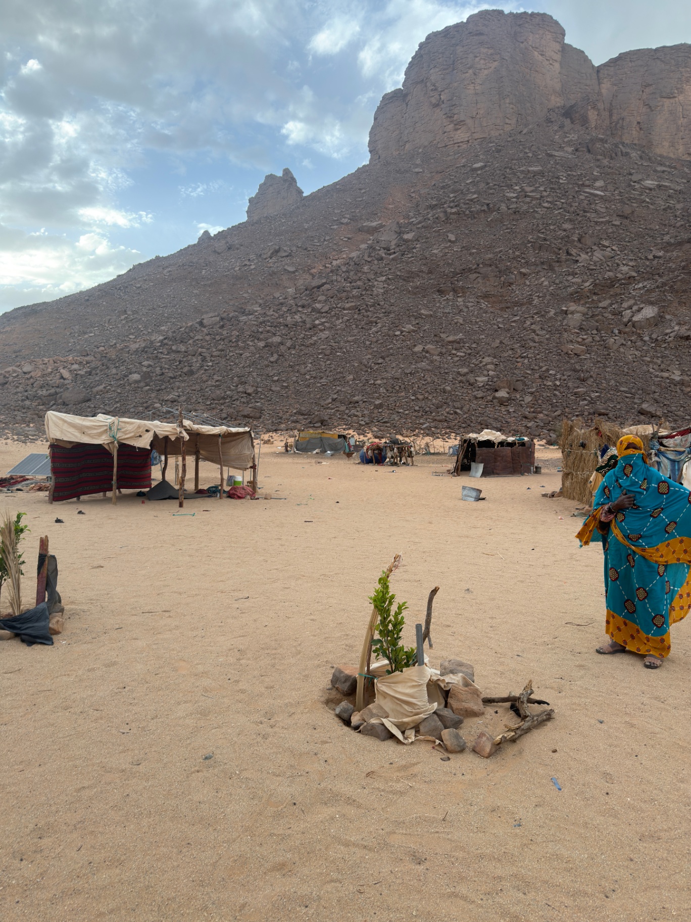 Campement touareg au pied d’un massif, femme en tenue traditionnelle