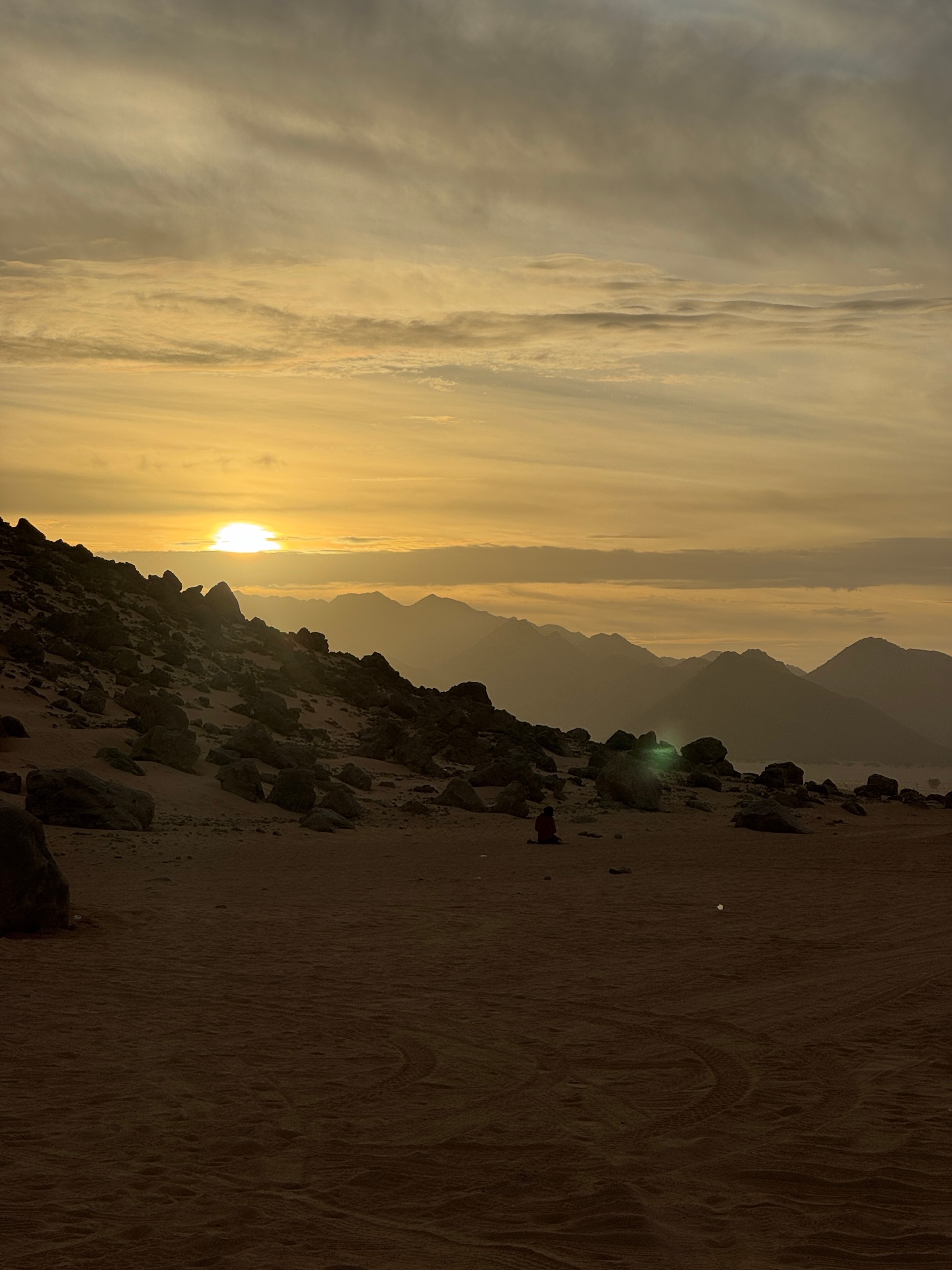 Silhouette contemplant le coucher de soleil sur les montagnes du Sahara