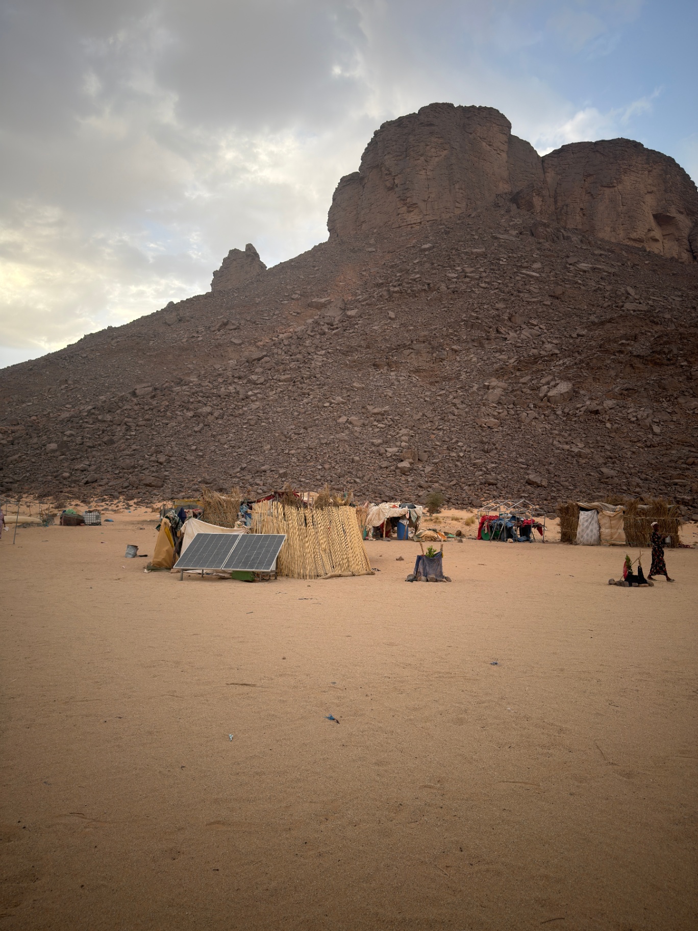 Campement nomade au pied d’un massif au crépuscule